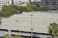 an empty parking lot in front of some tall buildings with palm trees in the foreground