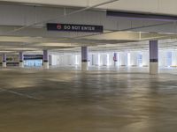 large parking garage area with various flooring and signs on the ceiling and in an empty lot