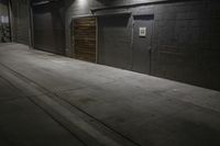 an empty parking lot with a sidewalk and large garage doors at night or day in the middle of winter