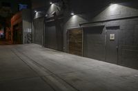 an empty parking lot with a sidewalk and large garage doors at night or day in the middle of winter