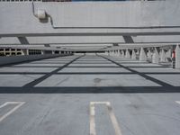 an empty parking lot covered in lots of columns and light posts with a street sign on one corner