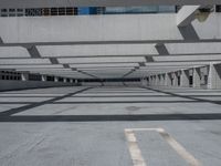 an empty parking lot covered in lots of columns and light posts with a street sign on one corner