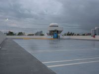 an empty parking lot with a blue door in the rain, with buildings in the background