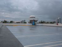 an empty parking lot with a blue door in the rain, with buildings in the background