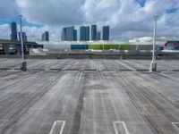 a view of an empty parking lot in front of a big building with tall buildings