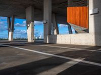 an empty parking lot with several tall cement poles and windows in the ceiling and some wood paneling on the floor