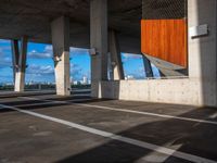 an empty parking lot with several tall cement poles and windows in the ceiling and some wood paneling on the floor