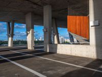 an empty parking lot with several tall cement poles and windows in the ceiling and some wood paneling on the floor