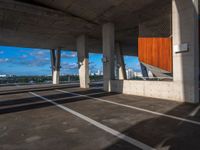 an empty parking lot with several tall cement poles and windows in the ceiling and some wood paneling on the floor