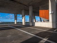 an empty parking lot with several tall cement poles and windows in the ceiling and some wood paneling on the floor