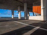 an empty parking lot with several tall cement poles and windows in the ceiling and some wood paneling on the floor