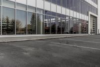 potholes in a parking lot full of water near an office building with glass windows