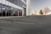 potholes in a parking lot full of water near an office building with glass windows