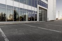 potholes in a parking lot full of water near an office building with glass windows