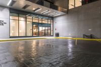 an empty parking lot covered in yellow tape near a building with a closed door and parking meter