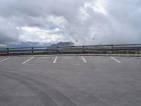 a parking lot with an empty area and mountains in the background next to it,