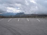 a parking lot with an empty area and mountains in the background next to it,