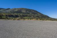 a bike sitting on top of an empty parking lot with mountains in the background and a blue sky