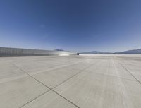 an empty parking lot with mountains in the background on a sunny day, near salt lake, utah