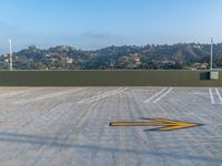 an empty parking lot near the city with yellow lines in it's asphalt surface