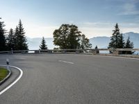 the parking lot for the motorcyclist is empty near trees and buildings, but it has no roads