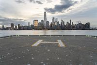 an empty parking lot in front of a city skyline on a hazy day by the water