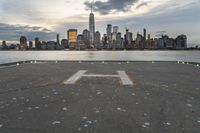 an empty parking lot in front of a city skyline on a hazy day by the water