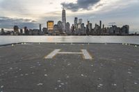 an empty parking lot in front of a city skyline on a hazy day by the water