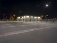 an empty parking lot at night with its lights on, and no one in sight