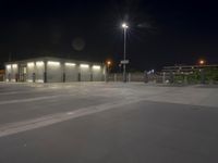 an empty parking lot at night with its lights on, and no one in sight