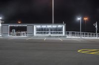 an empty parking lot at night with many lights and benches around it as well as multiple lamps