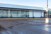 the empty parking lot has lots of windows and glass on it with a red fire hydrant in front