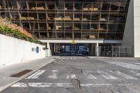 the parking lot outside of an office building is empty, with some signs on the street