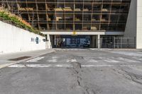 the parking lot outside of an office building is empty, with some signs on the street