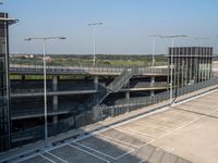 an empty parking lot has an overhead walkway leading to several parking lots in an open area