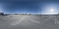 the 360 - view camera captures an empty parking lot surrounded by palm trees and airport buildings