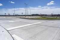 an empty parking lot with a paved surface and white arrows on the curb of it