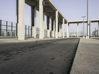 this image shows an empty area of a parking lot with pillars, the sky and street lights