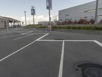 an empty parking lot with a fire hydrant near by and an elevated building to the right