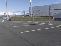 an empty parking lot with a fire hydrant near by and an elevated building to the right