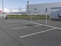 an empty parking lot with a fire hydrant near by and an elevated building to the right