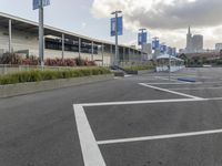 an empty parking lot with a fire hydrant near by and an elevated building to the right