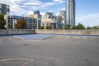 a parking lot that has an empty space with a skate board in it with many buildings behind it