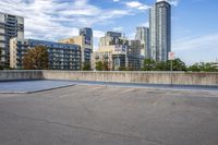 a parking lot that has an empty space with a skate board in it with many buildings behind it