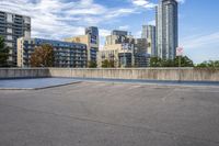 a parking lot that has an empty space with a skate board in it with many buildings behind it