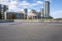 a parking lot that has an empty space with a skate board in it with many buildings behind it