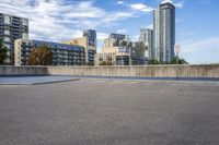 a parking lot that has an empty space with a skate board in it with many buildings behind it