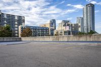 a parking lot that has an empty space with a skate board in it with many buildings behind it