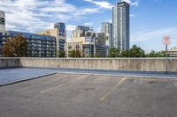 a parking lot that has an empty space with a skate board in it with many buildings behind it