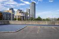 a parking lot that has an empty space with a skate board in it with many buildings behind it